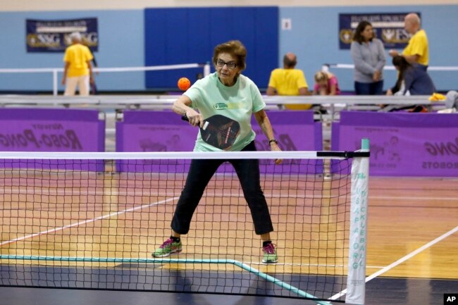 FILE - Leurene Hildenbrand, 85, competes in mixed doubles pickleball action during the Florida Senior Games presented by Humana on Saturday, Dec. 9, 2017 in Clearwater, Florida. (Brian Blanco/AP Images for Humana)