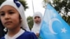 Seorang anak perempuan dari suku Uyghur memegang bendera Turkistan Timur dalam protes menentang penindasan yang dilakukan pemerintah China terhadap suku Uyghur, di Istanbul, Turki, pada 31 Agustus 2022. (Foto: Reuters/Dilara Senkaya)