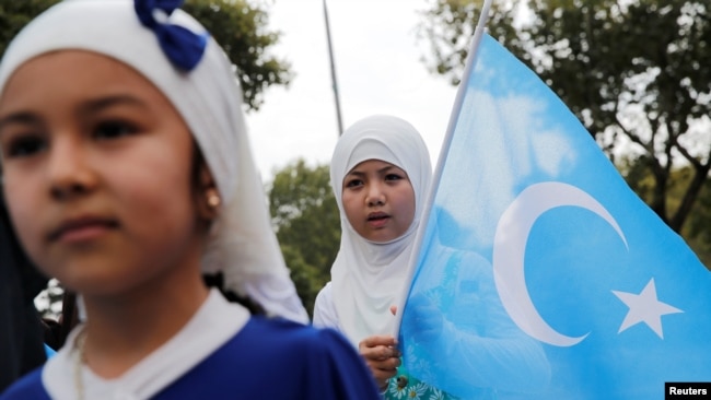 FILE - An ethnic Uyghur girl holds an East Turkestan flag during a protest against China in Istanbul, Turkey, Aug. 31, 2022. This month marks two years since the U.S. formally recognized China's mistreatment of Uyghurs and other Turkic Muslim populations in Xinjiang as genocide.