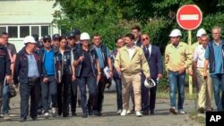 In this handout photo taken from video released by Russian Defense Ministry Press Service, International Atomic Energy Agency Director Rafael Grossi, center in white helmet, and IAEA members walk while inspecting the Zaporizhzhia Nuclear Power Plant in Ukraine, Sept. 1, 2022. 