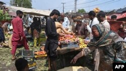 Sejumlah warga tampak membeli sayuran dan buah-buahan di pasar tradisional di Lahore, Pakistan, pada 30 Agustus 2022. Pakistan kini tengah dilanda kesulitan finansial dan terancam gagal membayar utang-utangnya. (Foto: AFP/Arif Ali)