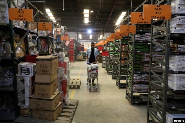 FILE - A worker at the Jumia company pushes a trolley cart between shelves in the warehouse in Lagos, Nigeria, Jan. 20, 2020.