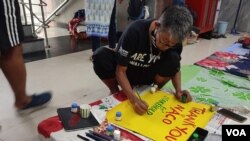 One of the HIV activists who took part in the New Delhi protest is creating a poster thanking India’s National Aids Control Organisation (NACO) and other related agencies, in New Delhi, Sept. 1, 2022. (Jitendra Jha/VOA)