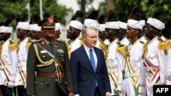 FILE - U.S. Ambassador to Sudan John Godfrey, the first U.S. ambassador to Sudan in 25 years, walks alongside a presidential guard during a ceremony at the presidential palace in Khartoum, Sept. 1, 2022.