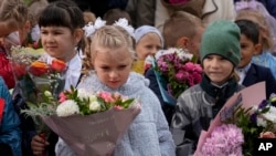 Escolares, la mayoría de ellos de primer grado, participan en una ceremonia que marca el inicio de clases en una escuela en Nakhabino, al oeste de Moscú, el 1 de septiembre de 2022.