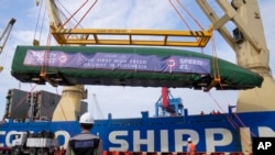 Workers unload part of a Chinese-made high-speed passenger train — prepared for the Jakarta-Bandung High-Speed Railway — from a cargo ship at Tanjung Priok Port in Jakarta, Indonesia, in September 2022.