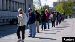 FILE - People line up outside a newly reopened career center for in-person appointments in Louisville, April 15, 2021.