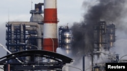 FILE - Smoke billows from an oil refinery owned by Russian oil producer Gazprom Neft, in Moscow, Russia, Nov. 17, 2018. 