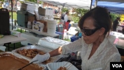 Penjual makanan Sus Grondin-Butler menyajikan sate ayam Indonesia, yang merupakan hidangan nasional Indonesia.  (Blok Deborah/Suara Amerika)