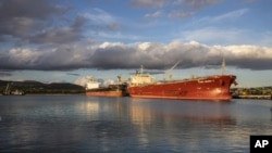 A coal barge and oil ship in Honolulu after the state received its last coal shipment, July 28, 2022. (Hawaii State Energy Office via AP)