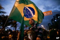 Supporters gather outside the residence of presidential candidate Jair Bolsonaro in anticipation of his victory speech, in Rio de Janeiro, Brazil, Sunday, Oct. 28, 2018.