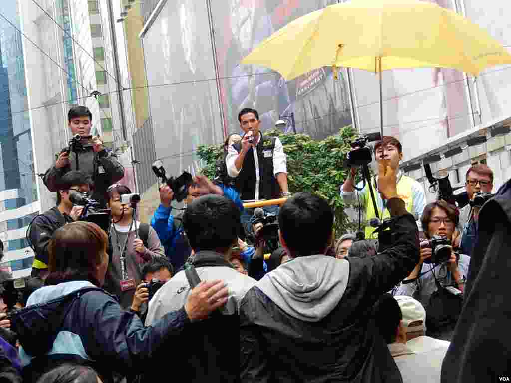 泛民立法會議員陳家洛(右一)在警方展開拘捕行動前高舉黃色雨傘 