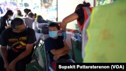 A health worker inoculates a boy with a dose of the Pfizer-BioNTech vaccine against COVID-19 at the Thai CDC’s vaccination mobile clinic at Wat Thai (Thai Temple) Los Angeles , Nort Hollywood, Los Angeles, CA. November 28, 2021.