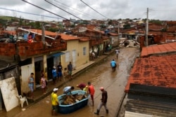 Residents clean out their flooded homes in Itapetinga, Bahia state, Brazil, Dec. 28, 2021.