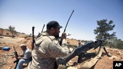 A Libyan rebel fighter uses a walkie talkie at their position in Misrata's western front line, some 25 km (16 miles) from the city center June 9, 2011