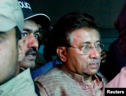 Pervez Musharraf (R) is escorted by security officials as he leaves an anti-terrorism court in Islamabad, April 20, 2013.