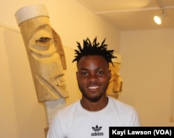 Atisso Goha, un artiste togolais qui sculpte en bois des œuvres géantes, à Lomé, Togo, le 19 avril 2019. (VOA/Kayi Lawson)