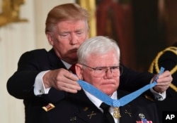 Description: President Donald Trump bestows the nation's highest military honor, the Medal of Honor, to retired Army Capt. Gary M. Rose during a ceremony in the East Room of the White House in Washington, Oct. 23, 2017.