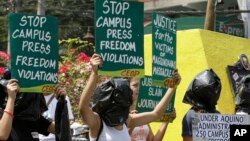 Protesters, with their heads covered in black plastic bags to symbolize their indignation allegedly for lack of justice, display placards during a rally to commemorate World Press Freedom Day near the Presidential Palace in Manila, Philippines, May 3, 2014.