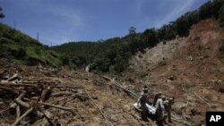 Firefighters, a National Force soldier and residents carry the body of a landslide victim from a home where the bodies of eight family members were found in Nova Friburgo, Rio de Janeiro state, Brazil, 20 Jan 2011