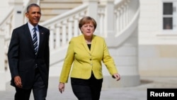 German Chancellor Angela Merkel and U.S. President Barack Obama walk to inspect the guard of honour during a welcoming ceremony at Schloss Herrenhausen in Hanover, Germany, April 24, 2016. 