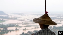 A woman looks out at flooded areas in Naypyitaw, Myanmar, Sunday, Sept. 15, 2024. (AP Photo/Aung Shine Oo)