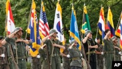 Para aktor mengenakan baju militer dengan bendera negara-negara yang ikut dalam Perang Korea, saat perayaan 70 tahun perang tersebut di Cheorwon, Korea Selatan, dekat perbatasan dengan Korea Utara, 25 Juni 2020.