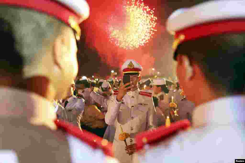 Para tentara mengambil foto selfie mereka saat upacara perayaan ulang tahun raja Thailand Bhumibol Adulyadej di luar Grand Palace di Bangkok. Raja Bhumibol membatalkan penampilannya di depan umum pada hari ulang tahunnya yang ke-87 atas saran dari para dokter kerajaan. Keputusan itu mengecewakan ribuan orang yang menunggu di luar rumah sakit tempat ia tinggal, yang berharap untuk melihat sang raja yang memiliki masa pemerintahan terpanjang di dunia. &nbsp;