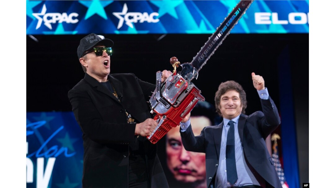 Elon Musk, left, receives a chainsaw from Argentina's President Javier Milei as they arrive speaks at the Conservative Political Action Conference, CPAC, at the Gaylord National Resort & Convention Center, Feb. 20, 2025, in Oxon Hill, Md.