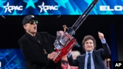 FILE - Elon Musk, left, receives a chain saw from Argentina's President Javier Milei at the Conservative Political Action Conference, CPAC, at the Gaylord National Resort & Convention Center, in Oxon Hill, Maryland, Feb. 20, 2025.