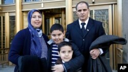 Nezha Hariz, left, poses with husband Mohamed Hariz and sons Nassim, 9, and Mouad, 7, outside a federal courthouse where they became U.S. citizens, March 18, 2016. The New York state family is from Morocco.