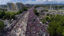 FILE - Demonstrators march on Las Americas highway demanding the resignation of Governor Ricardo Rossello, in San Juan, Puerto Rico, July 22, 2019.