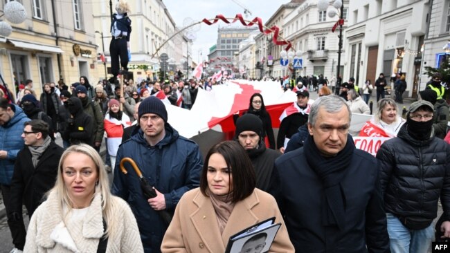 Udhëheqësja e opozitës bjelloruse në mërgim Svetlana Tikhanovskaya dhe politikani i opozitës Pavel Latushko ecin ndërsa anëtarët e diasporës bjelloruse mbajnë një flamur historik bjellorus 330 metra, të ndaluar në Bjellorusi, gjatë një tubimi në Varshavë. 26 janar, 2025