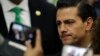 Invited guests take cell phone pictures of Mexico's President Enrique Pena Nieto following his address in response to the U.S. presidential election in Mexico City, Wednesday, Nov. 9, 2016.