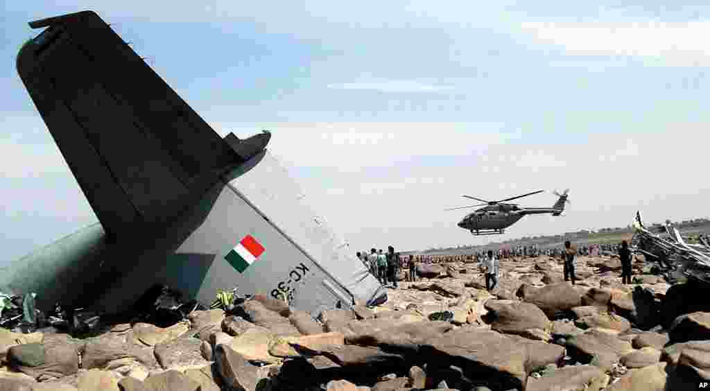 An Indian Air Force (IAF) helicopter hovers over the site where an IAF cargo plane crashed near Karauli village in the central Indian state of Madhya Pradesh. C-130J Hercules plane inducted into service just last year crashed during a training mission, killing all five crew members.