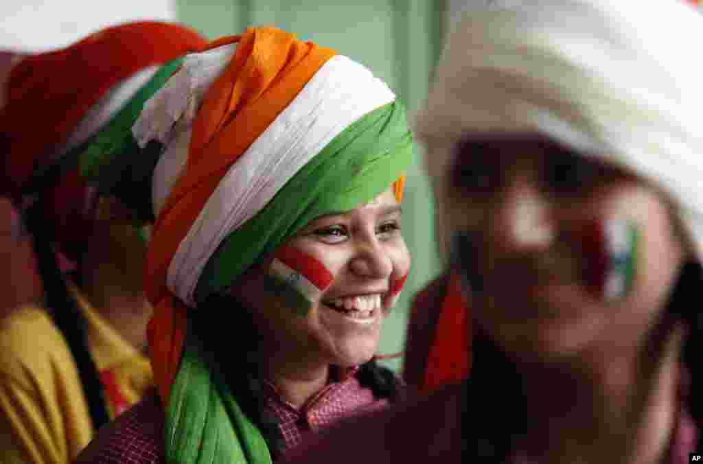 A girl, with her face painted in the tri-color Indian flag, smiles as she waits to perform during celebrations in a school on the eve of Independence Day in Jammu. India commemorates its independence in 1947 from British colonial rule on Saturday.