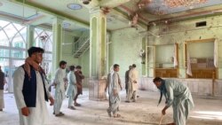 Afghan men inspect the damages inside a Shiite mosque in Kandahar on Oct. 15, 2021, after a suicide bomb attack during Friday prayers.