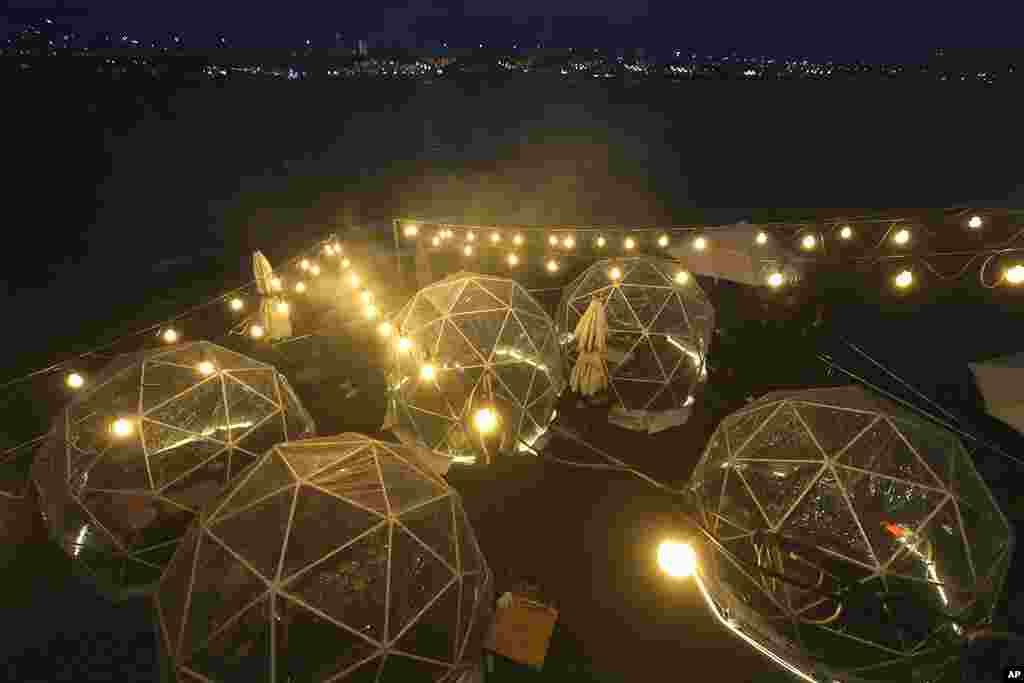 People dine outdoors in plastic bubbles, observing social distancing against the spread of the coronavirus at a restaurant near the Han River in Seoul, South Korea.