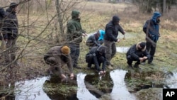 Lithuanian civilians use condoms to gather water from a creek during a survival course teaching them skills that some fear could be needed given Russia's resurgence, just outside of the capital Vilnius, Lithuania, Nov. 26, 2016.