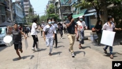 Pengunjuk rasa anti-kudeta lari untuk menghindari pasukan militer dalam aksi protes di Yangon, Myanmar, Rabu, 31 Maret 2021. (AP Photo)