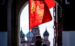 A Russian Communist party supporter carries a red flag as he walks along Red Square in Moscow, May 1, 2020.