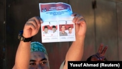 Seorang petugas pemilu memegang surat suara saat penghitungan suara pemilihan presiden di Makassar, Sulawesi Selatan, 9 Juli 2014. (Foto ilustrasi: REUTERS/Yusuf Ahmad)