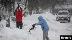 Los vecinos de Búfalo, en Nueva York, despejan la nieve acumulada frente a sus viviendas el 26 de diciembre de 2022.