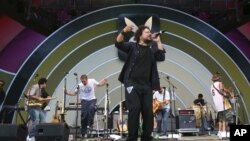 Asdru Sierra, center, of Ozomatli, performs during the Playboy Jazz Festival in Los Angeles, Sunday, June 18, 2006.