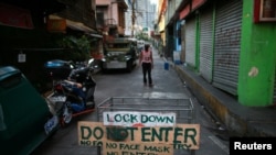 A makeshift barricade blocks a street from outsiders to protect a neighborhood from the spread of coronavirus disease in Manila, Philippines, March 23, 2020. 