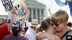 American University students Sharon Burk (L) and Molly Wagner embrace outside the Supreme Court after the court cleared the way for same-sex marriage in California by holding that defenders of California's gay marriage ban did not have the right to appeal lower court rulings striking down the ban, in Washington, D.C., June 26, 2013.