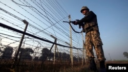 An Indian Border Security Force (BSF) soldier patrols near the fenced border with Pakistan in Suchetgarh, southwest of Jammu January 11, 2013. A flare-up in fighting on the Line of Control dividing India and Pakistan in Kashmir this week has cast a rare l