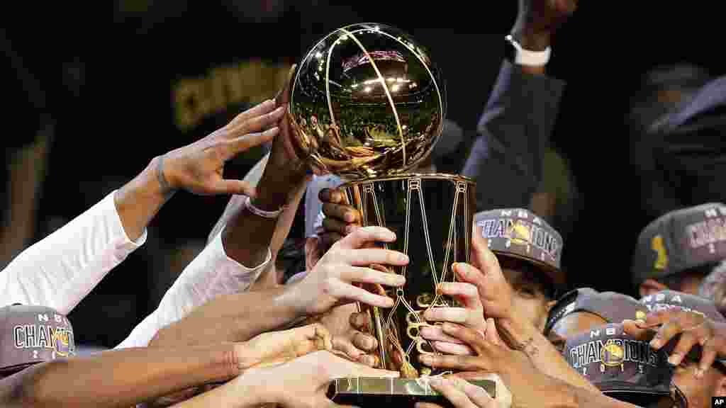 Les Golden State Warriors soulèvent le trophée alors qu&#39;ils célèbrent leur victoire aux Finales de la NBA contre les Cavaliers de Cleveland à Cleveland, mercredi 17 Juin 2015.