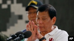 FILE - Philippine President Rodrigo Duterte gestures while addressing the Philippine Army Scout Rangers during his visit to their headquarters at Camp Tecson in San Miguel township, north of Manila, Philippines, Sept. 15, 2016.