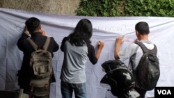 Aksi penggalangan tanda tangan untuk mendesak aparat mengusut kasus kekerasan jurnalis di depan kantor AJI Jakarta. (Foto: VOA/Sasmito)